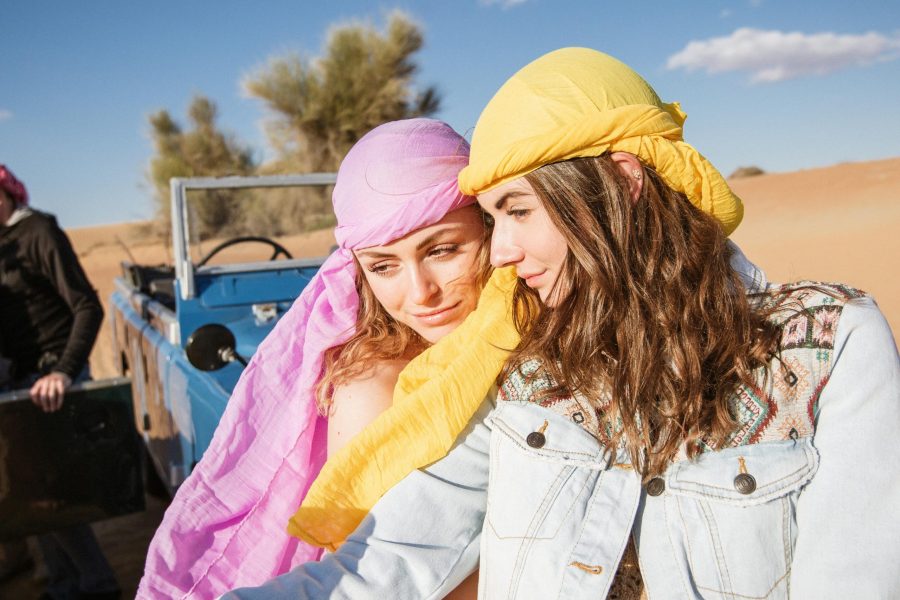 Two young tourists taking a selfie in a desert safari, capturing a memorable travel moment.